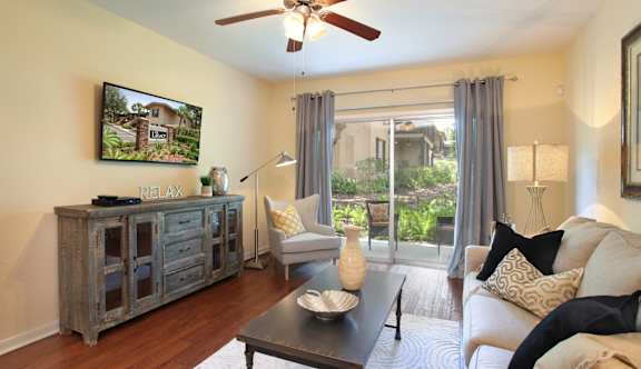 A living room with a couch, a coffee table, and a painting on the wall  at The Legacy Apartments in Seminole Heights, FL