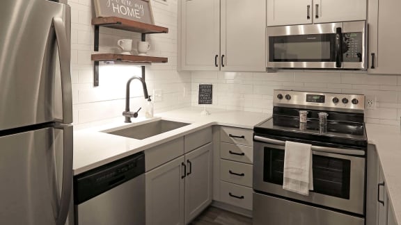 a kitchen with white cabinets and stainless steel appliances