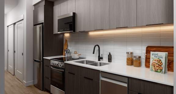 A modern kitchen with dark wood cabinets and stainless steel appliances.