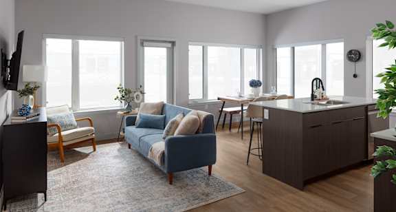A living room with a blue couch and wooden floors.