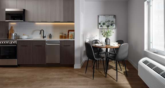 A modern kitchen with a dining table set for two.