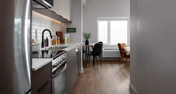 A kitchen with a refrigerator, stove, and sink.