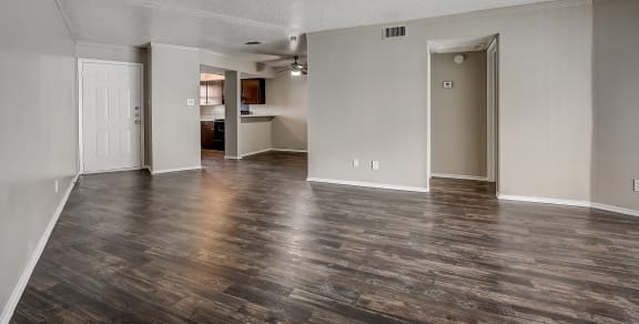 an empty living room with a hardwood floor