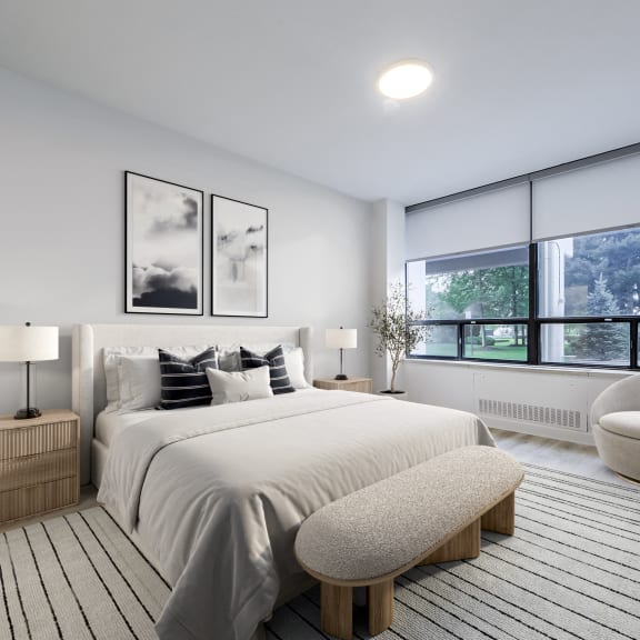 a white bedroom with a large bed and a large window