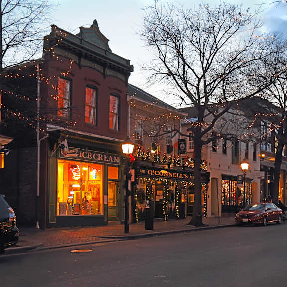 A street scene with cars and a building with an ice cream shop.