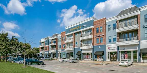 an empty parking lot in front of a building with cars parked in front