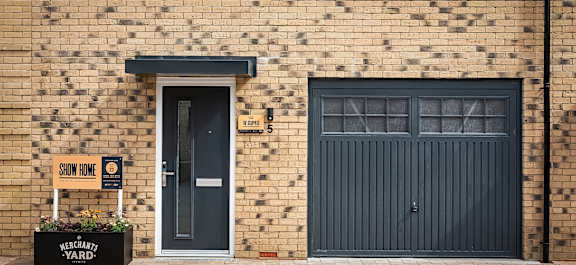a brick building with a blue door and a brick sidewalk