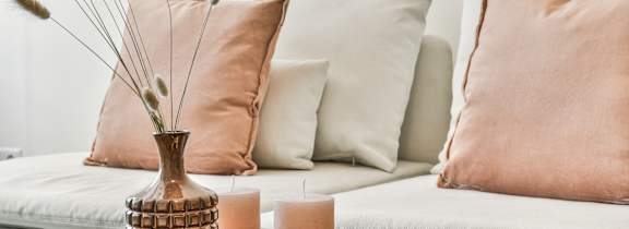 A table with a vase, candles, and a decorative item on it.