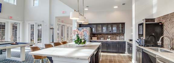 A kitchen with a granite countertop and stainless steel appliances.