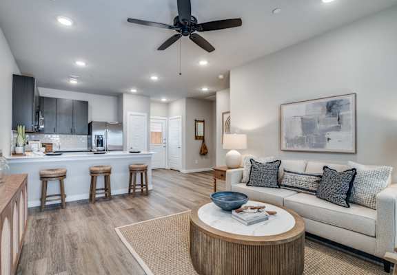 A modern living room with a ceiling fan and a white couch.