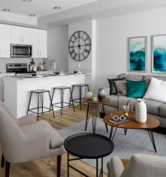 a kitchen and living room with a large island with stools