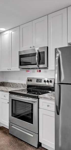 a kitchen with white cabinets and stainless steel appliances