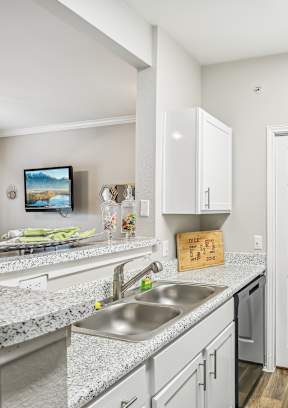 A kitchen with black appliances and white cabinets.