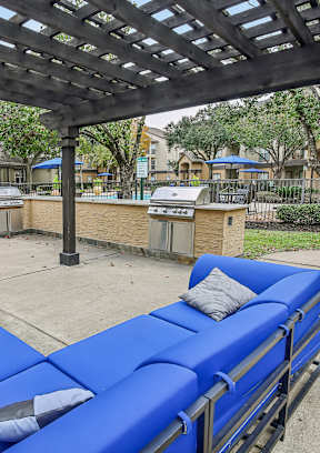 A blue lounge chair under a wooden pergola.