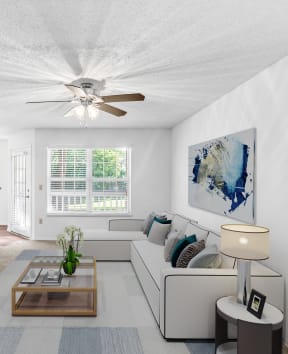 a living room with white walls and a ceiling fan