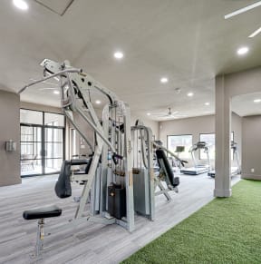 a home gym with a green carpet and gray walls