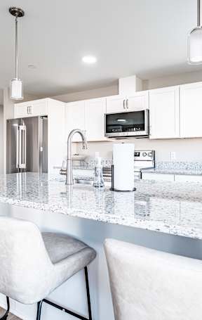 Spacious kitchen island with granite countertops and seating at Windham Village Apartments, Windham, ME