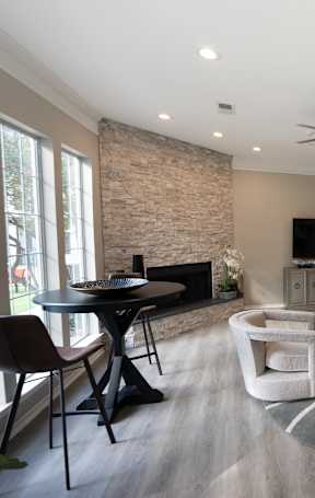 a living room with chairs and a table and a television