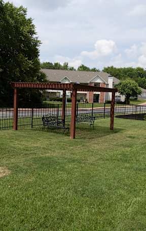 a park with a fenced in area with a pergola