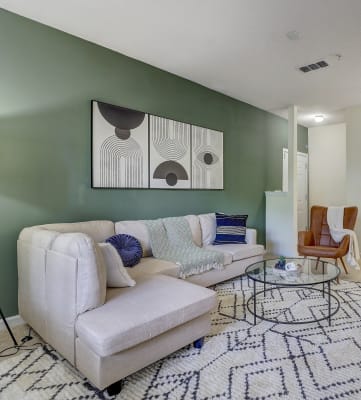 a living room with a green accent wall and a white couch