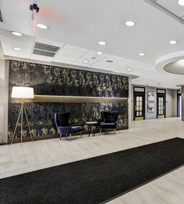 a large lobby with a reception desk and black rugs