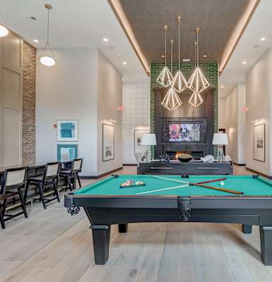 a billiards room with a pool table and chairs