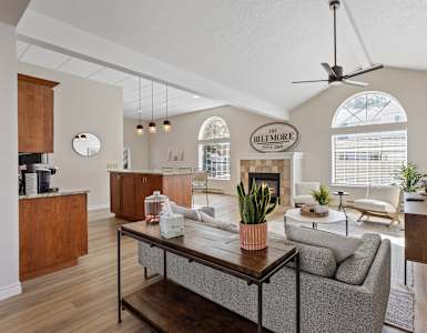 A living room with a couch, a coffee table, and a ceiling fan.