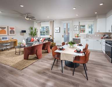 an open living room and kitchen area with a dining table and chairs