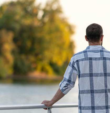 a man standing on a boat overlooking a lake