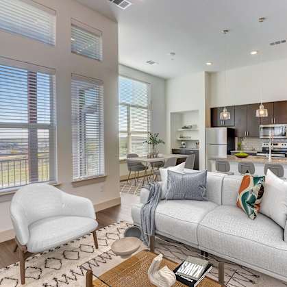 an open living room and kitchen with a couch and chairs