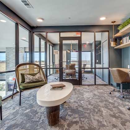 a conference room with a table and chairs and large windows