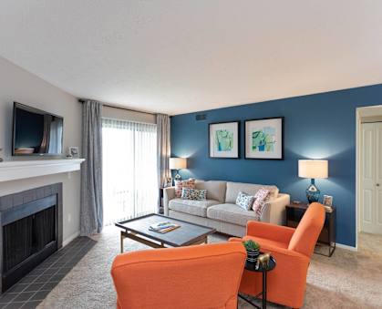 a living room with blue walls and a white couch and a fireplace at Chinoe Creek Apartments in Lexington KY