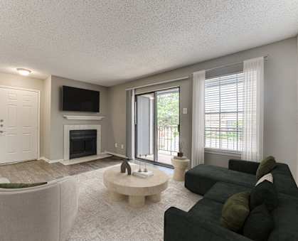 A living room with a black couch and a fireplace.