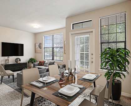 A modern dining room with a wooden table set for two.