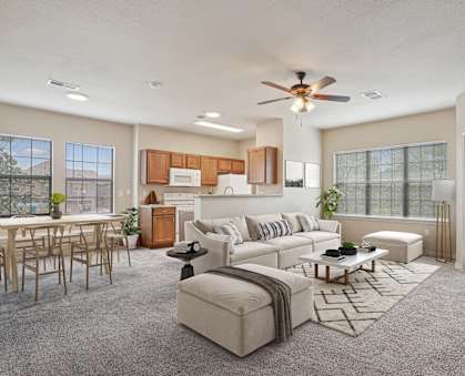 A living room with a white couch and a wooden dining table.