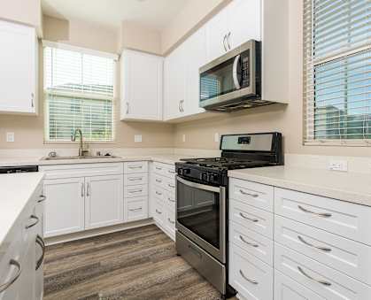 a kitchen with white cabinets and stainless steel appliances