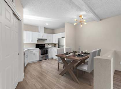 an open kitchen and dining room with a wooden table and chairs