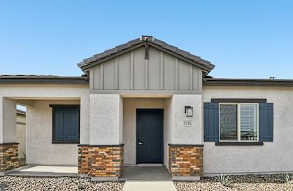 A house with a grey roof and a black door with the number 1016 on it.