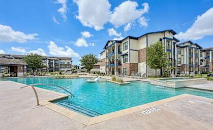 A swimming pool in front of apartment buildings.