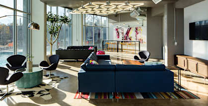 A modern living room with a blue couch and a large window.