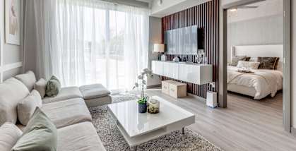 A modern living room with a white sofa and a glass coffee table.