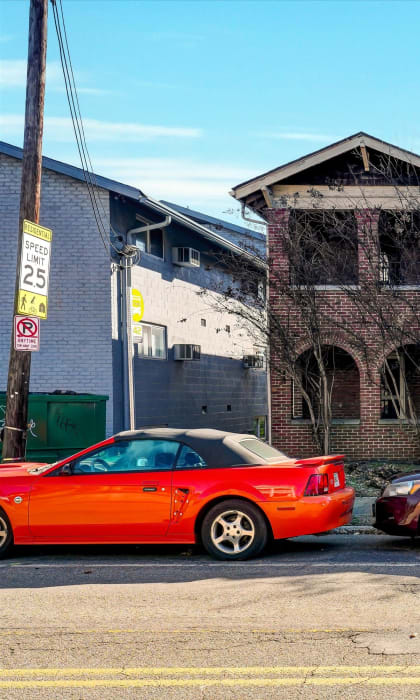 an old brick house with cars parked in front of it