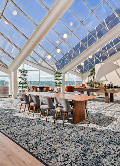 A modern dining area with a glass ceiling and wooden furniture at 7 West 7th Apartments, Ohio, 45202