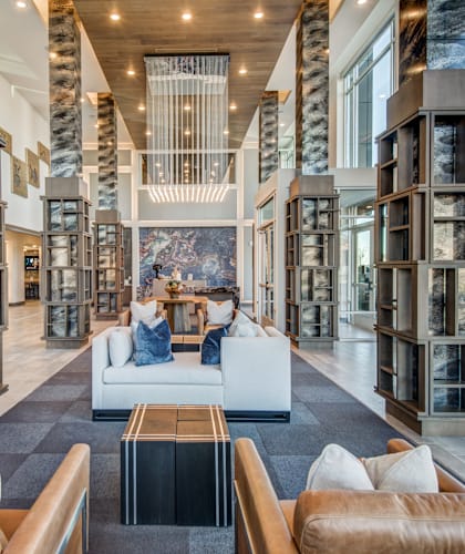 A large room with a long white couch and a black coffee table.