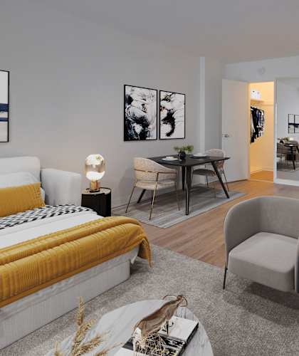 A modern bedroom with a yellow bed and a grey armchair.