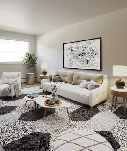 A living room with a white couch, a coffee table, and a large abstract painting on the wall.