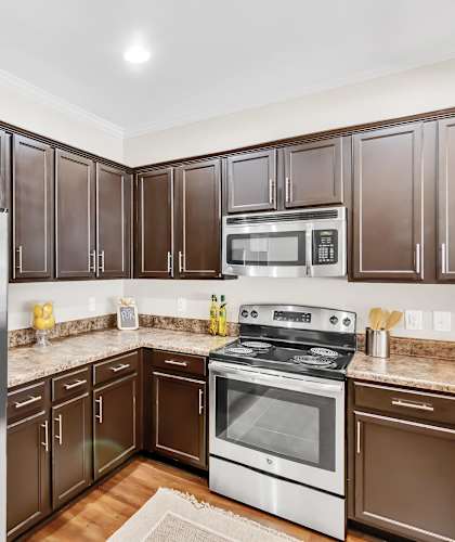 A kitchen with brown cabinets and a stainless steel refrigerator.
