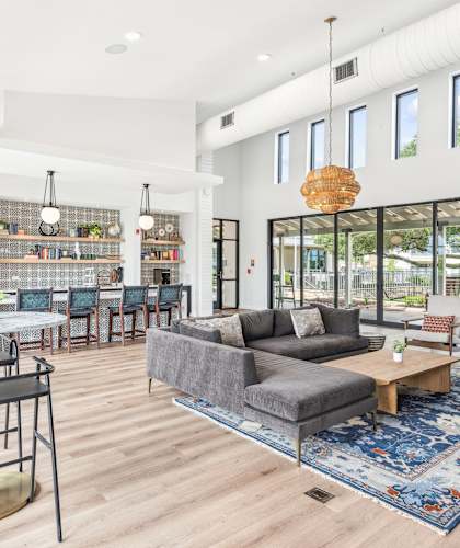 A modern living room with a grey couch and a round table.