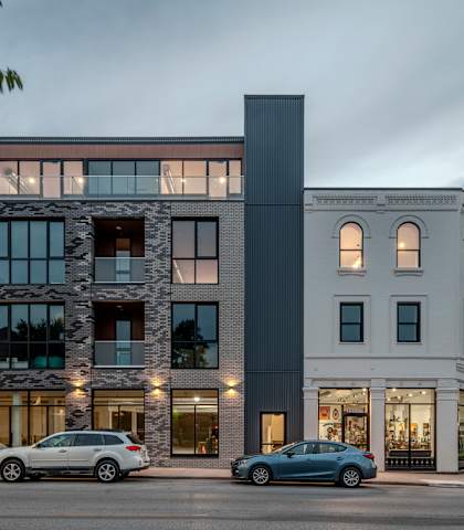 the exterior of a building with cars parked in front of it