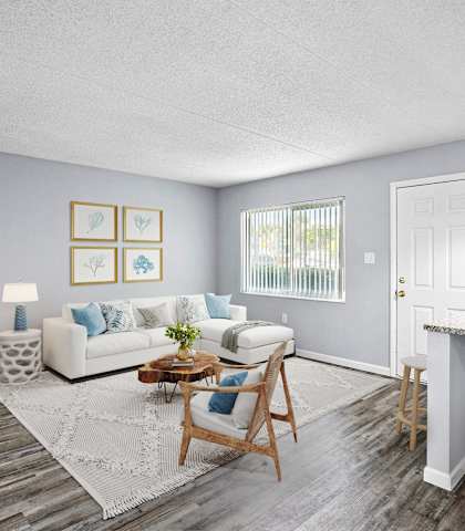A living room with a white couch, a coffee table, and a dining table.